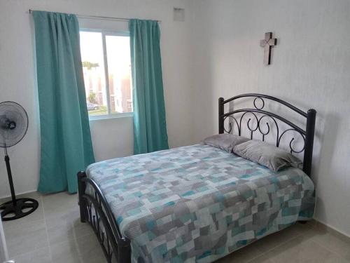 una camera da letto con un letto con tende verdi e una finestra di Casa Guerra en Maderos residencial -ideal para familias y viaje de trabajo a Cancún