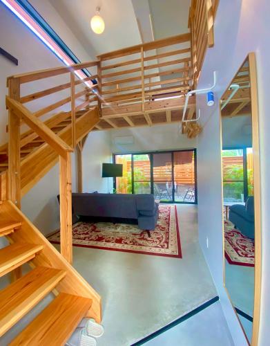 a living room with a loft bed and a couch at Hotel Little Swiss House in Motobu