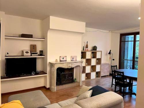 sala de estar con sofá y chimenea en Luminoso e accogliente appartamento a San Donato, en San Donato Milanese