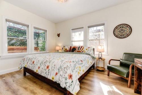 una camera con letto, sedia e finestre di Vintage 50s Victorian Styled Apt in Old Roseville a Roseville