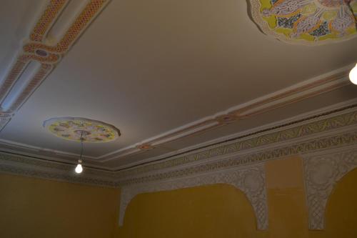a room with a ceiling with a painting on it at Maison D'hote Amazir in Boumalne