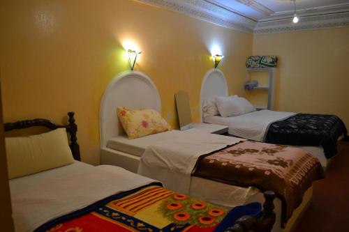 Cette chambre comprend 3 lits. dans l'établissement Maison D'hote Amazir, à Boumalne