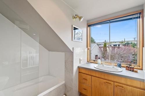 a bathroom with a sink and a tub and a window at Lakeside Indulgence on Wilmot in Queenstown