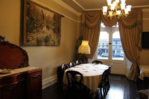 una sala da pranzo con tavolo, sedie e finestra di Emmet House a Birr