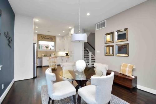 a dining room with a table and white chairs at Skyline Views with Garage Parking 10 minutes from Downtown, NRG Stadium and Medical CTR in Houston