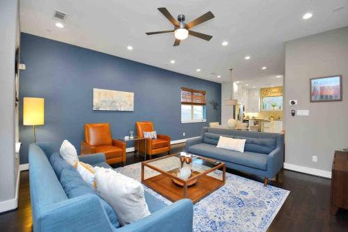a living room with blue furniture and a ceiling fan at Skyline Views with Garage Parking 10 minutes from Downtown, NRG Stadium and Medical CTR in Houston