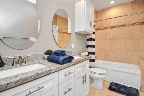 a bathroom with a sink and a toilet and a mirror at Skyline Views with Garage Parking 10 minutes from Downtown, NRG Stadium and Medical CTR in Houston