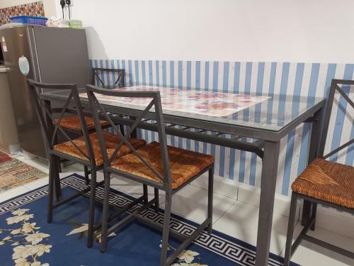a glass table with two chairs and a table and a table and chairs at AniS Homestay 2 @ Nilai in Nilai