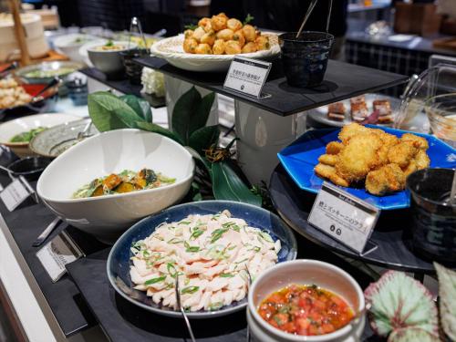 a buffet filled with different types of food on plates at THE BLOSSOM KYOTO in Kyoto