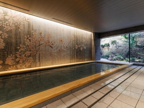 a swimming pool in a building with a painting on the wall at THE BLOSSOM KYOTO in Kyoto