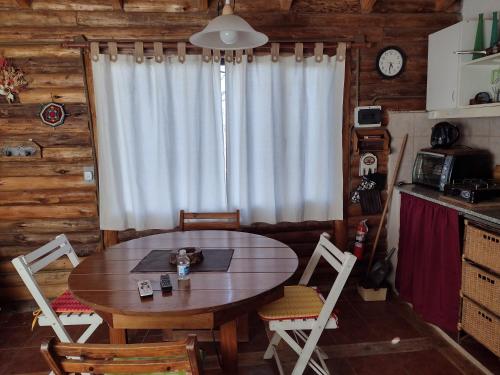 Una mesa y sillas en una cocina con ventana. en Cabaña Sonnentahl 2, en Potrerillos