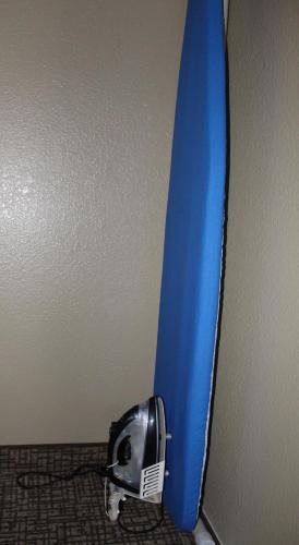 a blue surfboard leaning against a wall with a helmet next to it at Bristol Arcadia Inn in Bristol