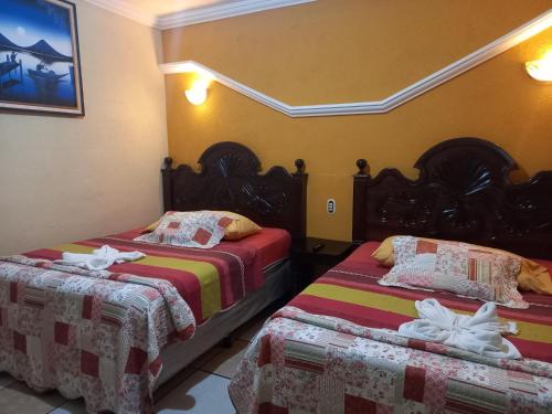 a room with two beds in a room at Hotel Tinamit in San Pedro La Laguna