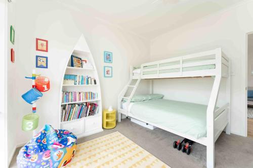 a bedroom with a bunk bed and a book shelf at Boomer Beach Retreat- Pet and Family Friendly in Port Elliot