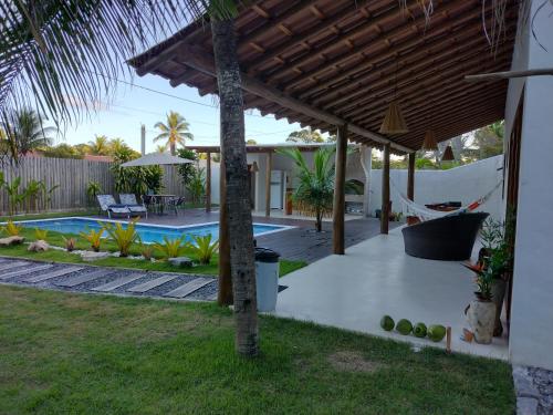 un patio trasero con piscina y pérgola en Casa Harmonia, com 5 suítes em Trancoso-BA en Trancoso