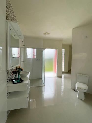 Aguas Mornas的住宿－AMPLA CASA DE CAMPO - MORADA DA SERRA，白色的浴室设有卫生间和水槽。
