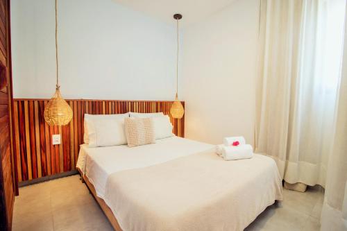 a bedroom with a large bed with a stuffed animal on it at Apartamento Manay in Jericoacoara