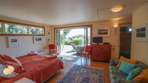 a bedroom with a bed and a living room at Hokianga Haven in Opononi