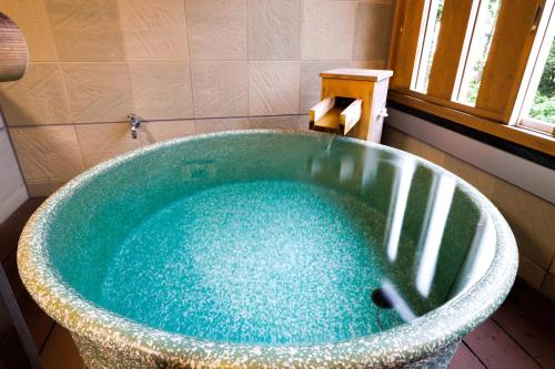 a bath tub with a water fountain in a bathroom at KAMENOI HOTEL Itako in Itako
