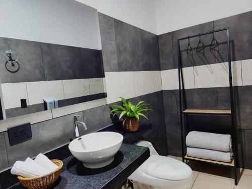 a bathroom with a sink and a toilet at Hotel Capri Doradal in Doradal