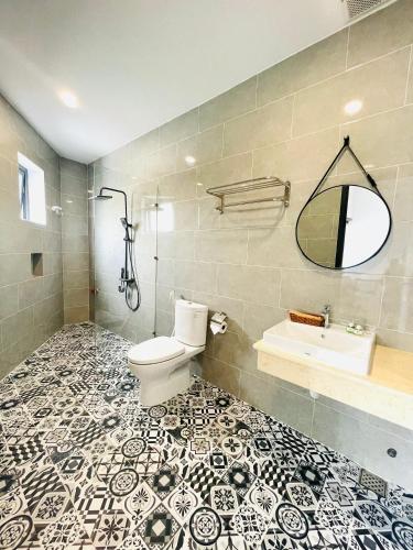 a bathroom with a toilet and a sink and a mirror at Phu Quoc Village in Phú Quốc