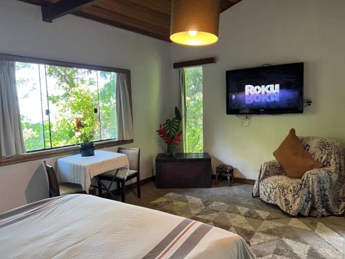 a bedroom with a bed and a tv on the wall at Amazing forest House in the city! Private guest suite - double studio room in Rio de Janeiro