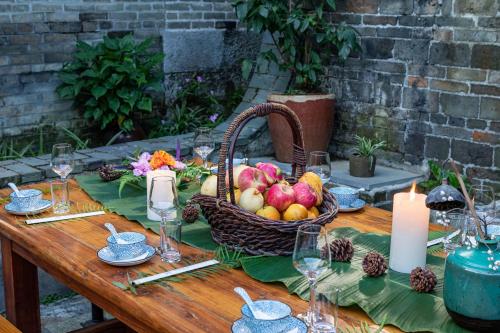 a picnic table with a basket of fruit and candles at Yangshuo Secret Garden in Yangshuo