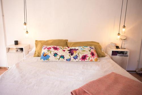 Una cama blanca con una almohada encima. en Habitación privada en Nuestra Casa del Pueblo en Esquel