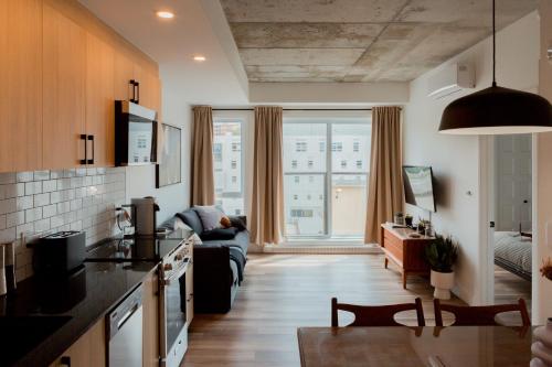a kitchen and living room with a couch at CONDO MID-CENTURY MODERN STYLE - POOL/TERRACE in Quebec City