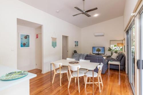 a kitchen and living room with a white table and chairs at Mobys Resort 35 in Boomerang Beach