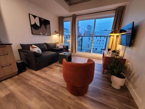 a living room with a couch and a large window at CONDO MID-CENTURY MODERN STYLE - POOL/TERRACE in Quebec City