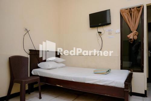 Sawojajar Inn Mitra RedDoorz tesisinde bir odada yatak veya yataklar