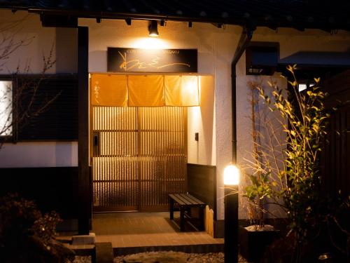 a door to a building with a bench in front at Yufuin Wasaku in Yufuin