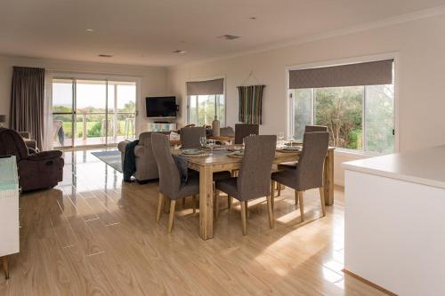 a dining room and living room with a table and chairs at Aldinga Bay Bungalow Ocean View Retreat in Sellicks Beach