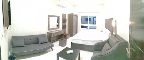 a living room with a bed and a couch and a table at Sharm Beach Suites Private hotel apartments in Yanbu