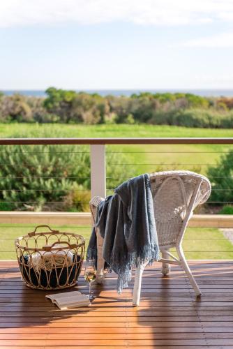 a blanket sitting on a chair on a deck at Aldinga Bay Bungalow Ocean View Retreat in Sellicks Beach