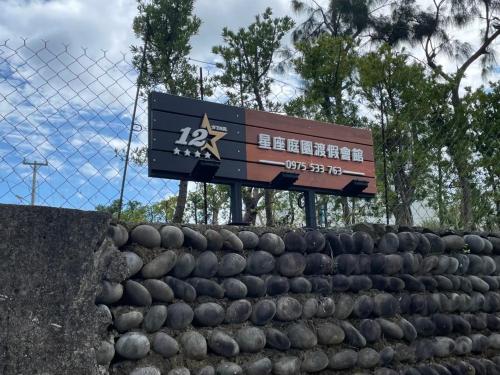 a sign for a baseball game behind a fence at Twelve Constellation Garden Resort in Hengchun