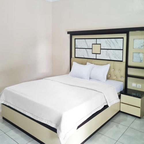 um quarto com uma grande cama branca e uma janela em RedDoorz @ Jalan Nyai Enat Sampit em Sampit