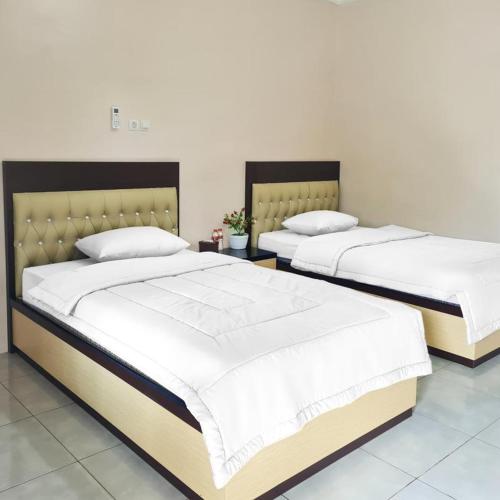 dwa łóżka siedzące obok siebie w pokoju w obiekcie RedDoorz @ Jalan Nyai Enat Sampit w mieście Sampit