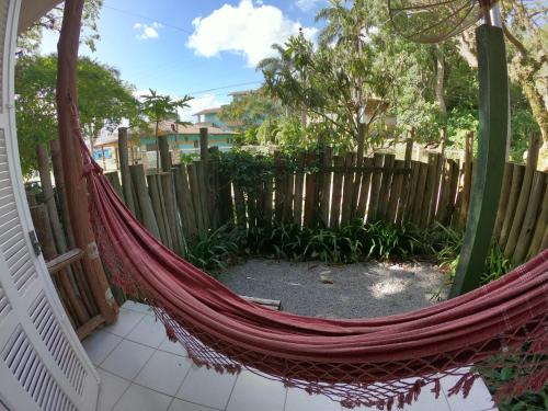 a hammock on a porch with a fence at Pousada Canoa Azul na Praia da Ferrugem in Garopaba