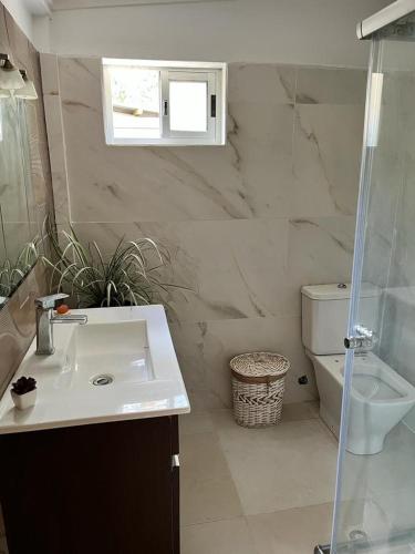 a bathroom with a sink and a toilet at Complejo El Refugio - Las Toscas in Las Toscas