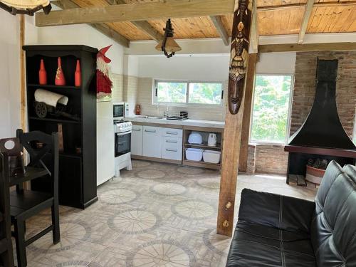 a kitchen with a couch and a stove top oven at Complejo El Refugio - Las Toscas in Las Toscas