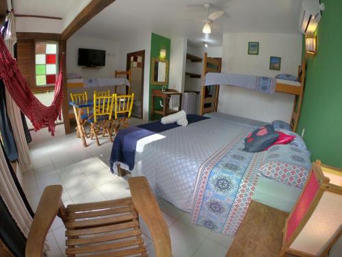 a bedroom with a bed and a dining room at Pousada Canoa Azul in Garopaba
