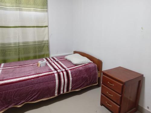 a small bedroom with a bed and a dresser at Hostel Home Trotamundos in Chachapoyas
