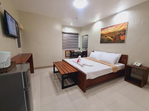 Un dormitorio con una cama y una mesa. en Grace & RB Hotel en Kalibo