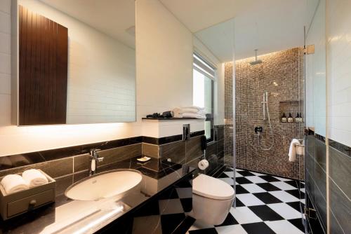 La salle de bains est pourvue d'un lavabo, de toilettes et d'une douche. dans l'établissement Wyndham Sky Lake Resort and Villas, à Hanoï