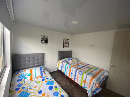 twee bedden naast elkaar in een slaapkamer bij Apartamento tipo finca lleno de vida y elegancia. in Neira