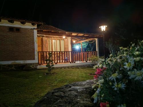 a house with a gate and a porch at night at CABAÑAS LOS LAURELES in Huasca de Ocampo