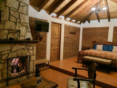 1 dormitorio con chimenea, 1 cama y TV en CABAÑAS LOS LAURELES, en Huasca de Ocampo