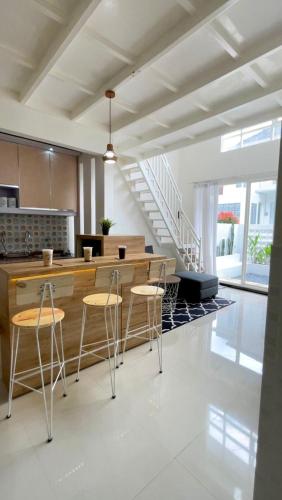 a kitchen with a counter and stools in a room at Villa Tiga Dara Batu in Batu